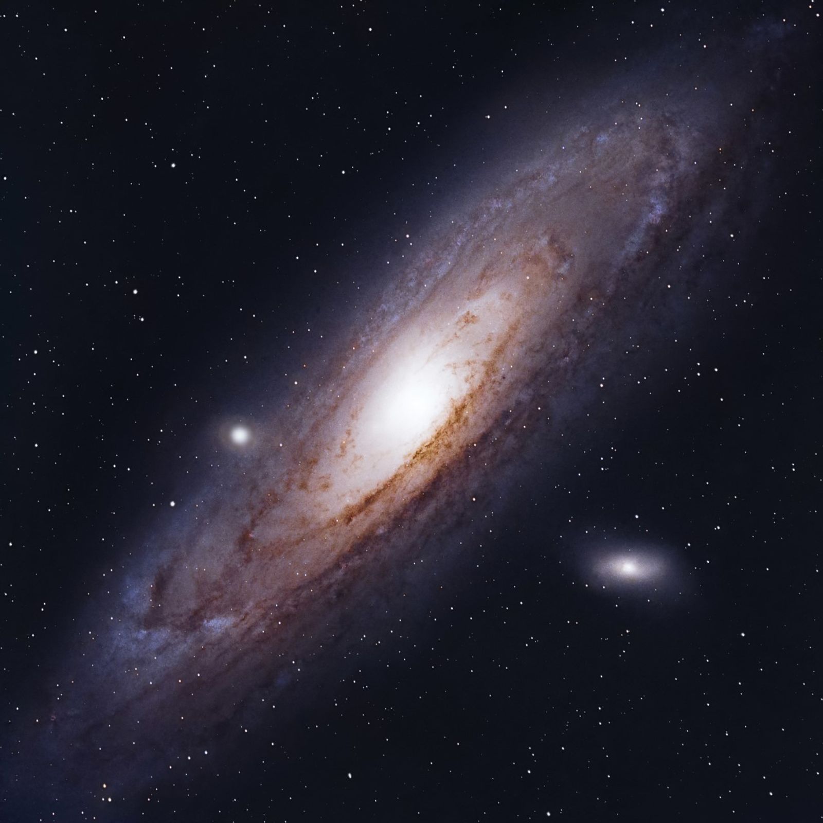 Andromedan Galaksi, joka on kierteisgalaksi jonka ulommat kierteet ovat hieman violetteja ja häilyvämpiä, sisärenkaat ovat kirkkaita ja vaaleita