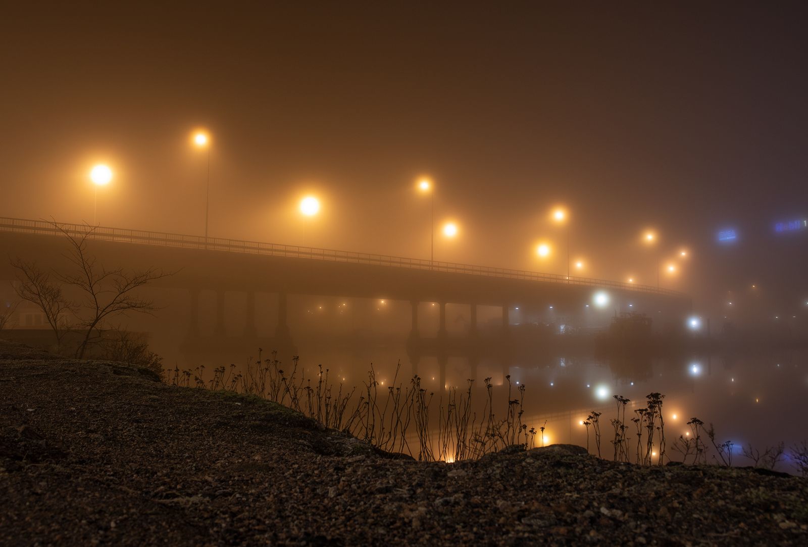 Sumuinen silta, jota valaisevat katuvalot sumun peitossa