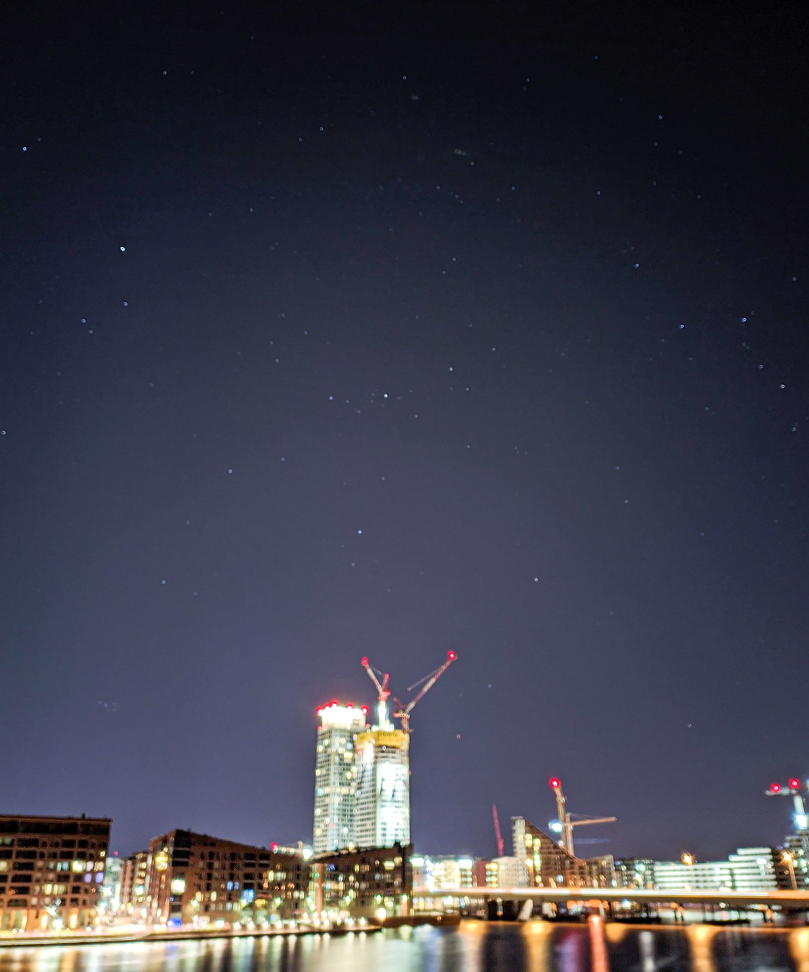Helsingin Kalasatama kuvattu puhelimella yöllä, kuva on laadultaan huono mutta muutamat tähdet voi erottaa