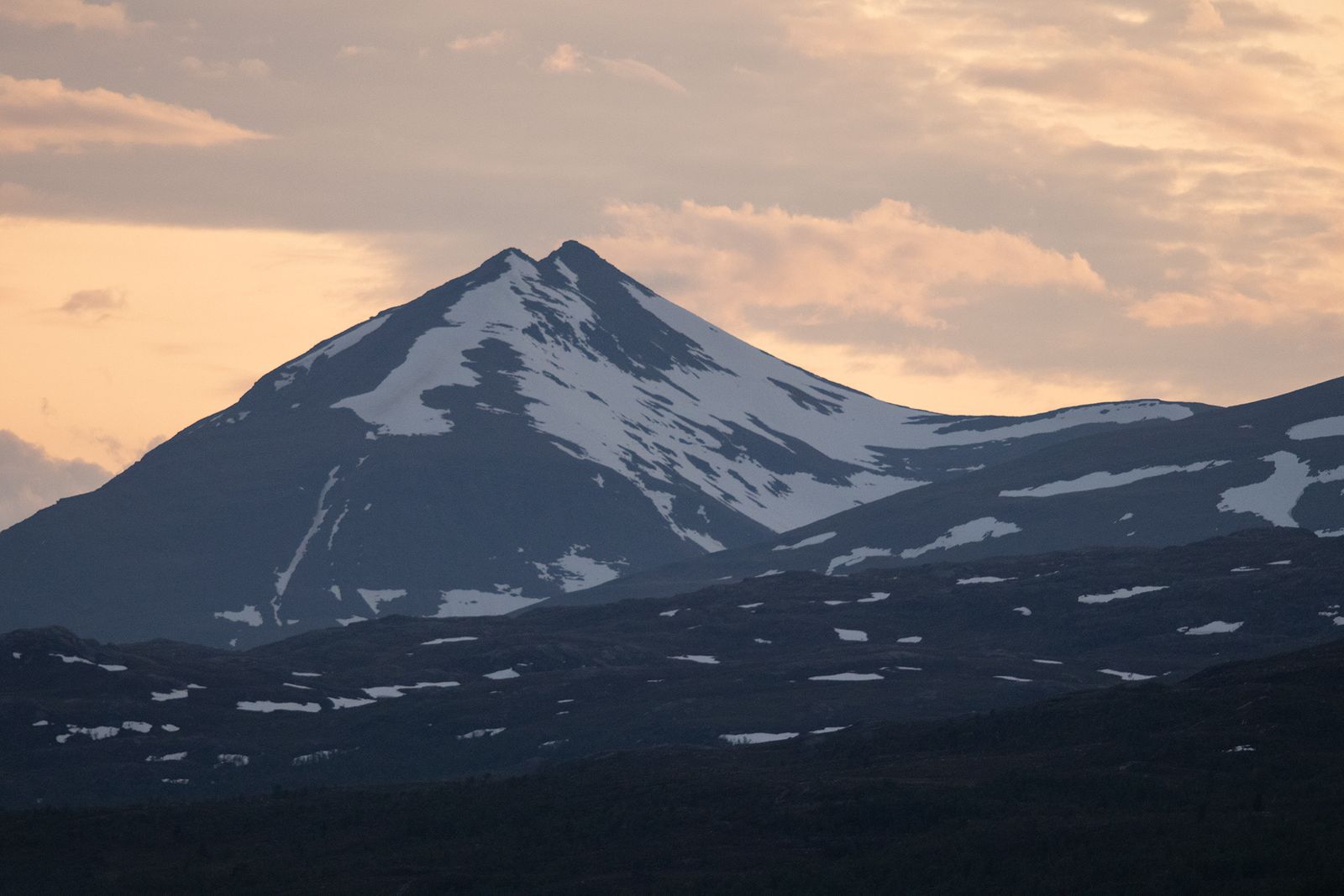 Luminen Norjan vuori ja oranssi pilvinen taivas