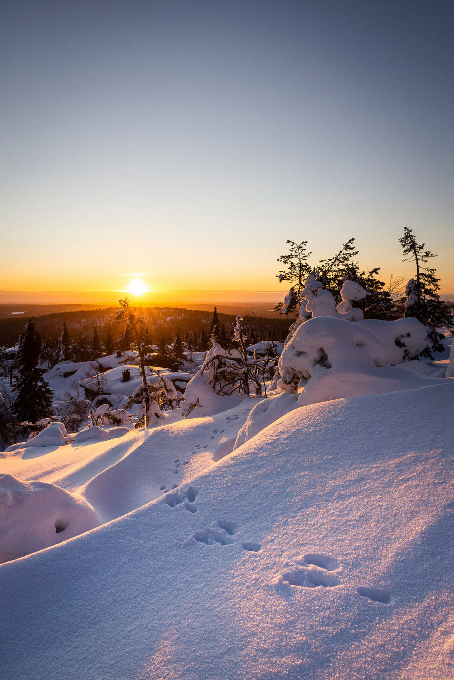 Luminen maisema mäen päältä kohti auringonlaskua