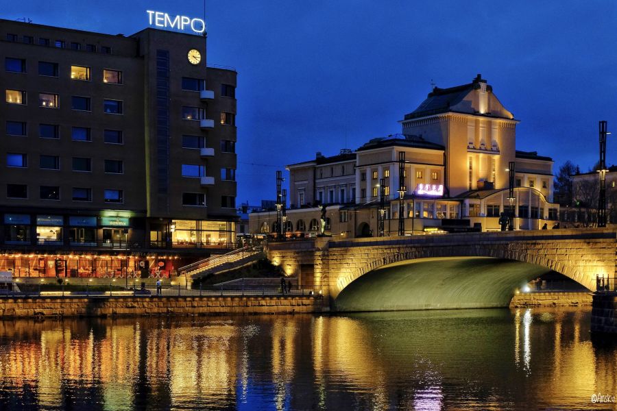 Tampere kuvattuna yöllä 2020. Kaupungin valot heijastuvat kaupungin läpi menevään jokeen.
